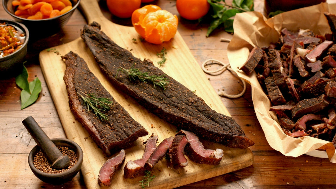 The image shows a smorgasbord board with biltong, a popular South African dried meat snack.